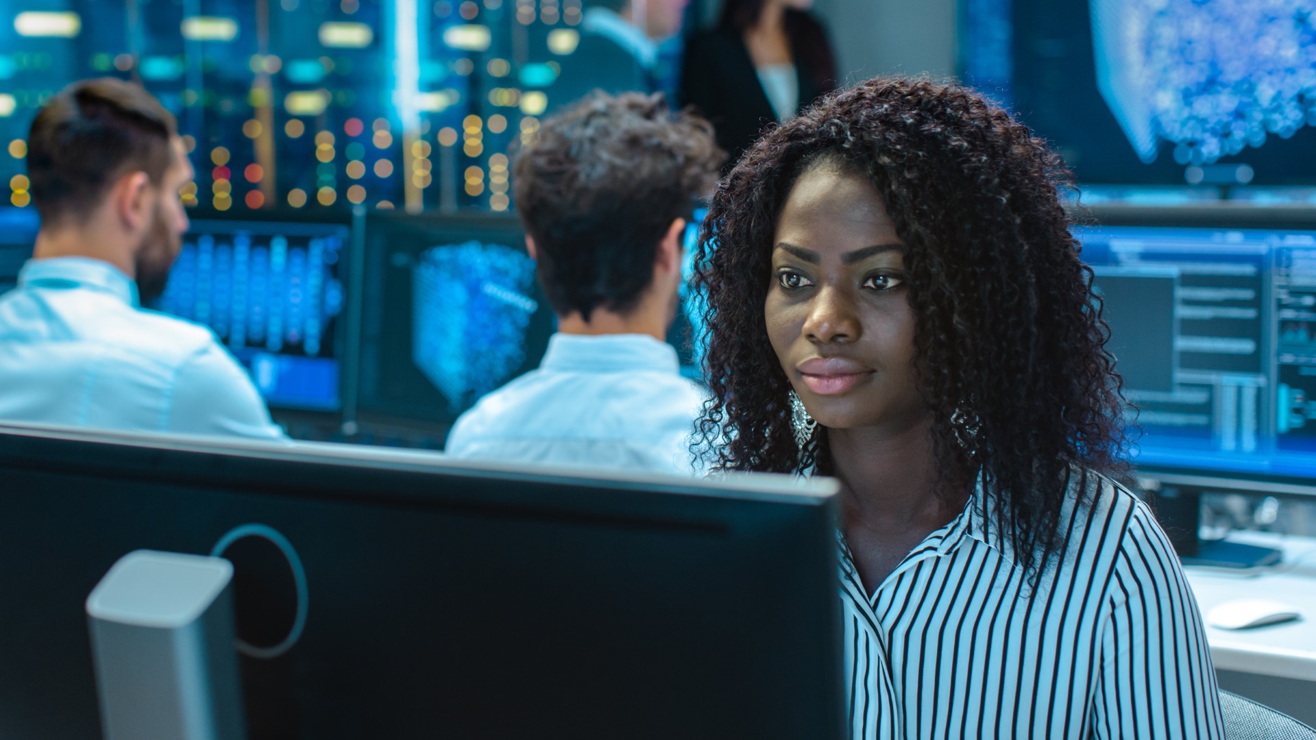 Digital forensic expert sits at computer monitor, analyzing cause and scope of healthcare data breaches.