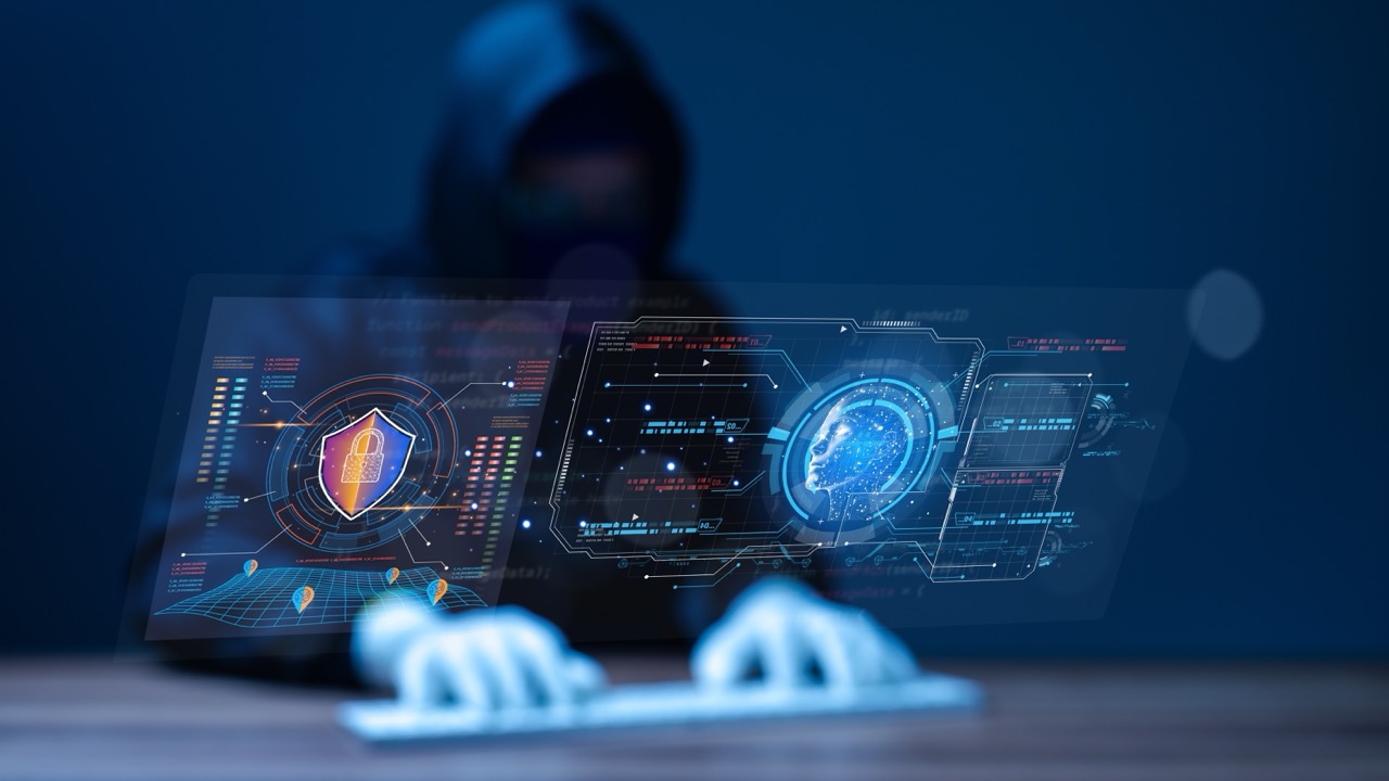 Hacker in hoodie sits at computer keyboard, while digital images of screens display artificial intelligence in cyber security programs. 