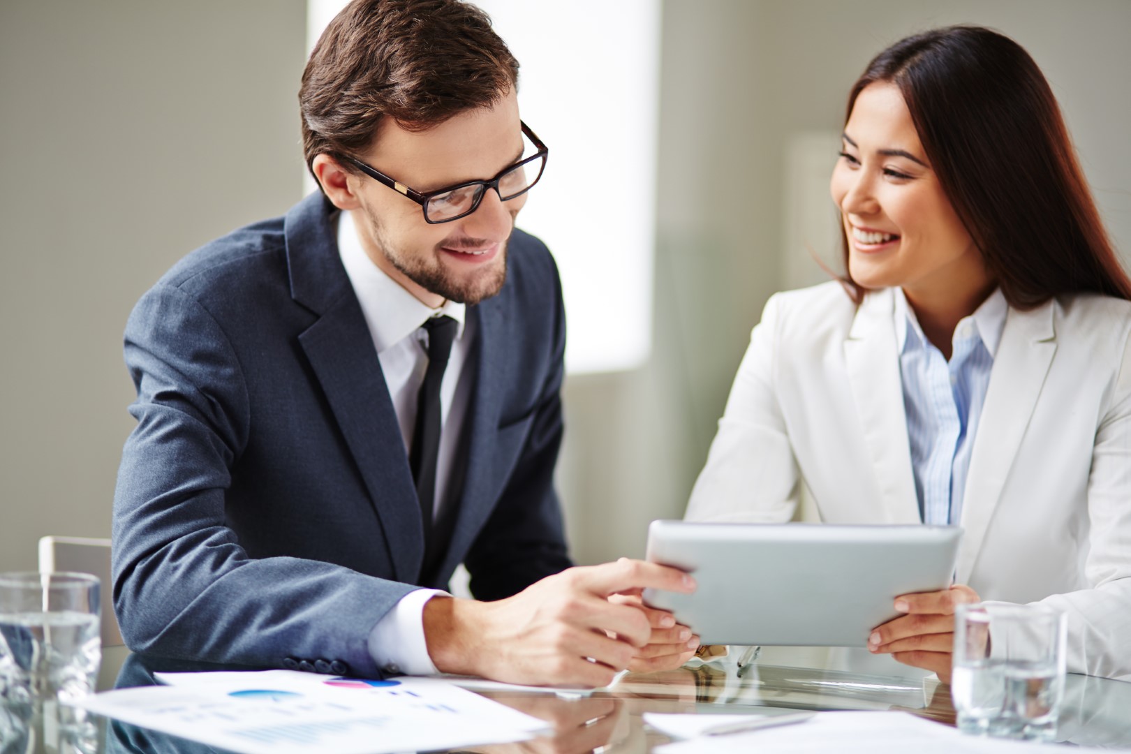 Insurance broker displays funds transfer fraud coverage policy details to her client on a tablet computer. 