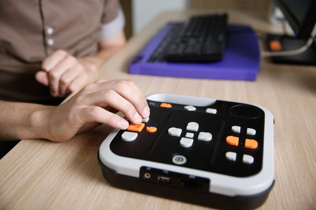 Close up of a blind person’s hands using an audio book player.