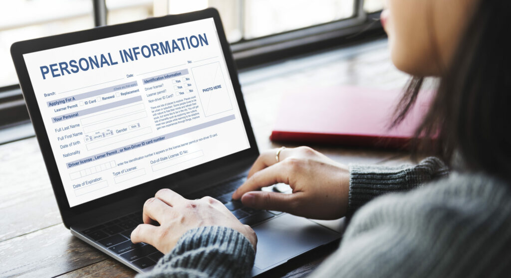 Image of woman entering personal information into a company application form via laptop.